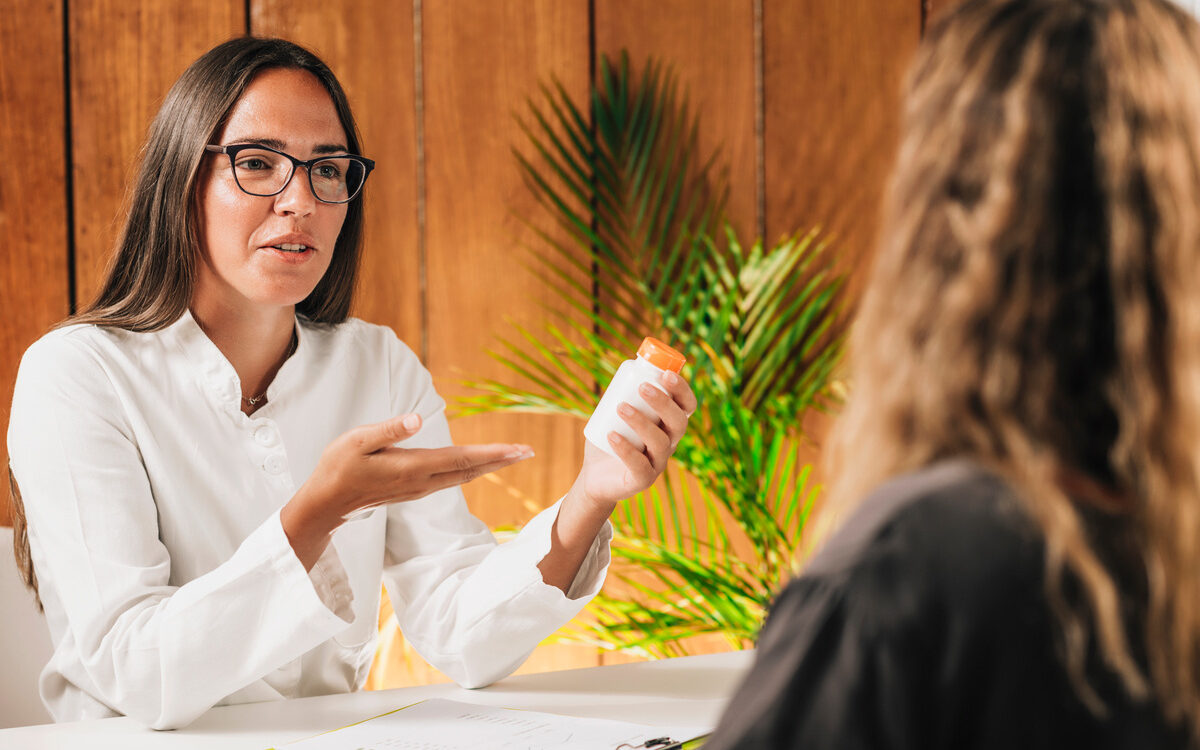 A female provider discussing bioidentical HRT vs synthetic HRT options with a female patient during a hormone therapy consultation