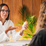 A female provider discussing bioidentical HRT vs synthetic HRT options with a female patient during a hormone therapy consultation