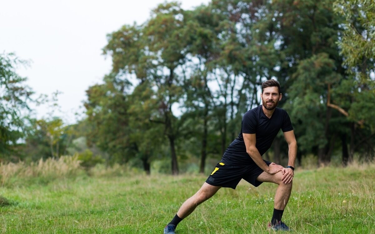 Man stretching outdoors after discovering how long does TRT take to work through consistent testosterone replacement therapy