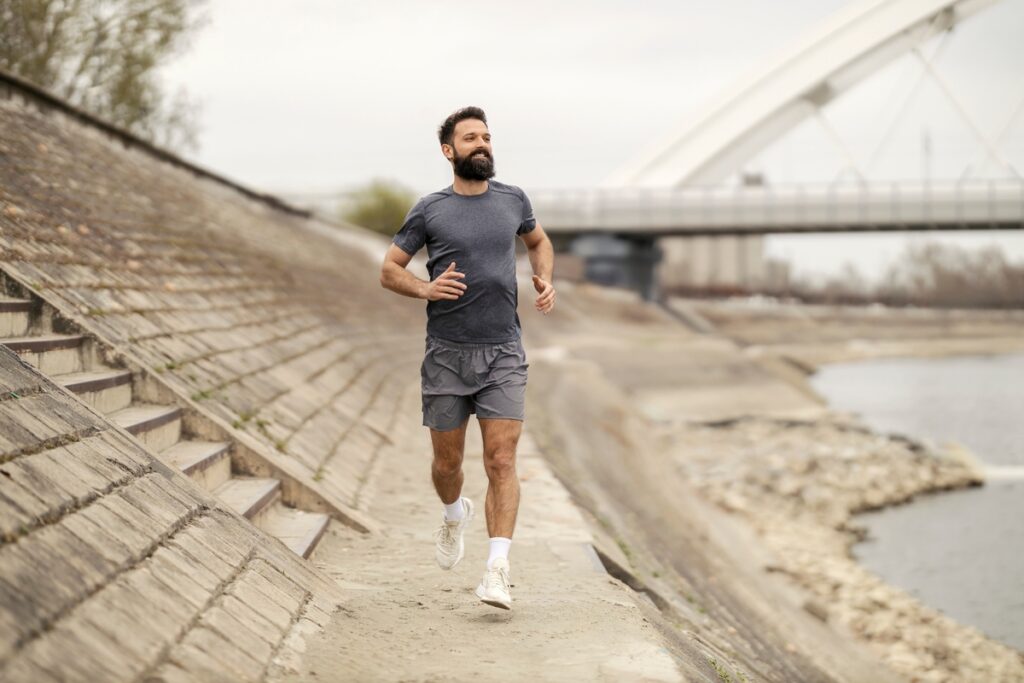 Active man jogging along the river, representing renewed energy from TRT in Fruit Cove FL